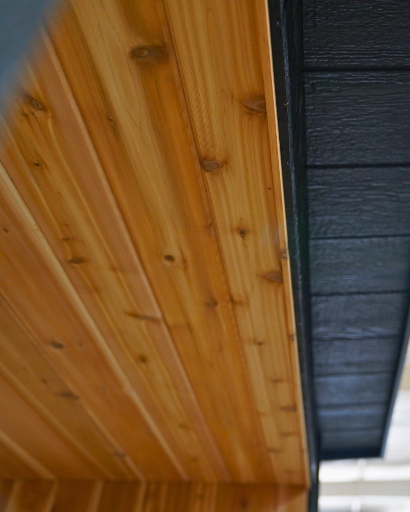Tongue and groove cedar ceiling beside the black roof edge